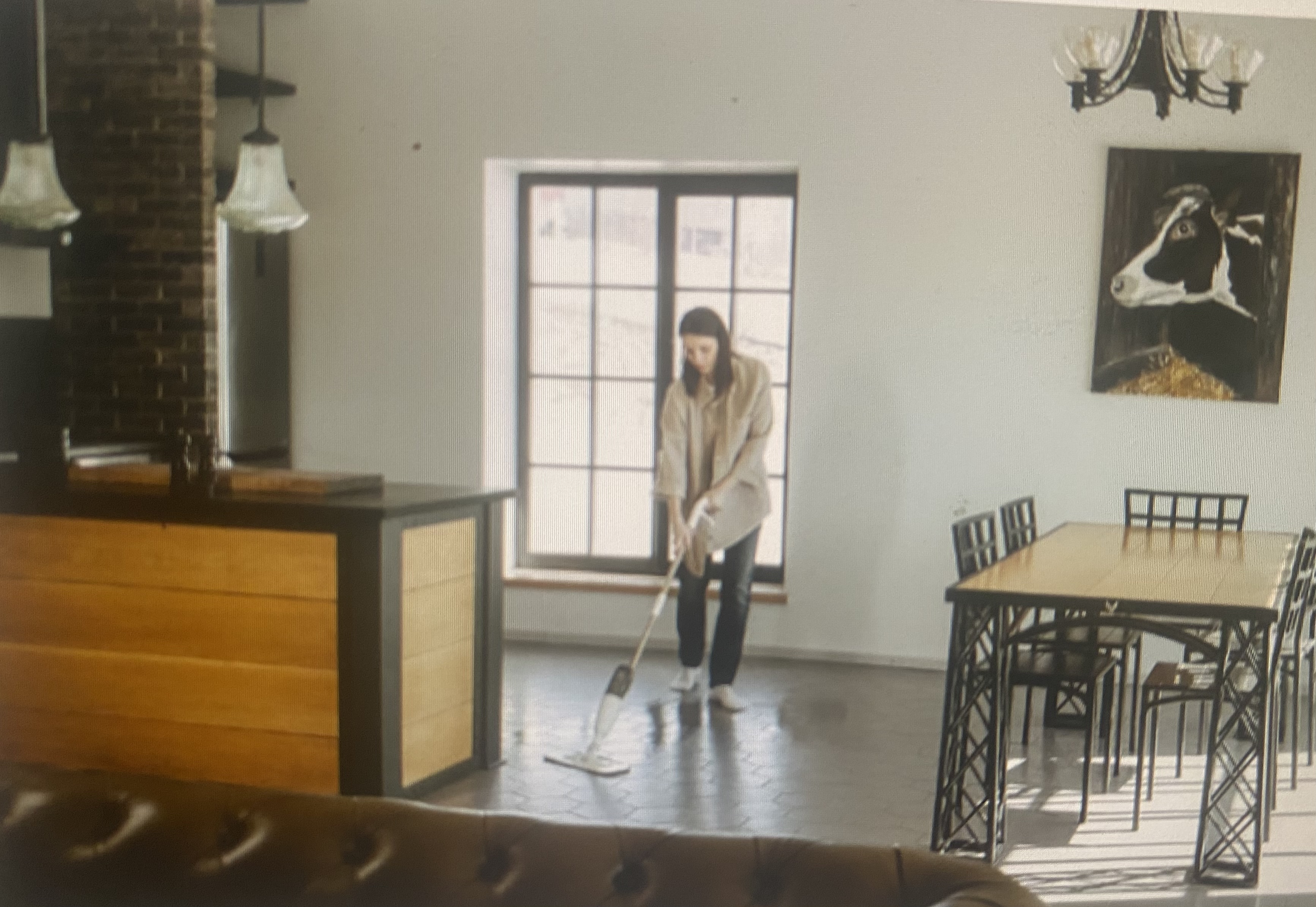 A woman cleaning a small apartment that she shares with a dog